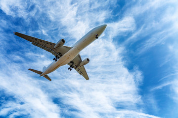 Fototapeta na wymiar Passenger plane in a bright cloudy blue sky, Close-up.
