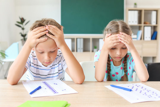 Pupils passing difficult school test in classroom