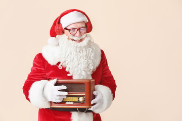 Portrait of Santa Claus with retro radio receiver on light background