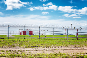 Fototapeta premium Airfield with planes behind the fence.