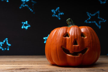 Halloween pumpkin on a background of blue blurry stars, lights. With space for design, festive mood