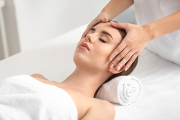 Obraz na płótnie Canvas Young woman having facial massage in beauty salon