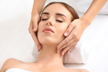 Young woman having facial massage in beauty salon