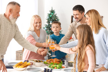 Happy family clinking glasses during Christmas dinner at home