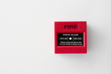 Modern manual call point of fire alarm system on light wall