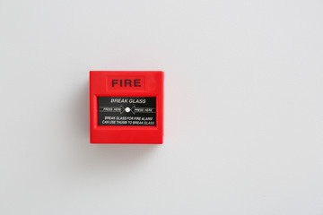 Modern manual call point of fire alarm system on light wall