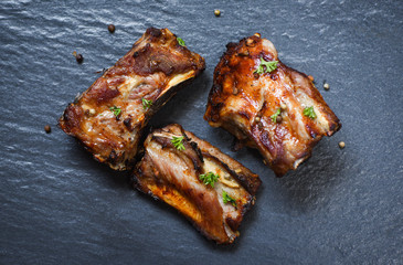 bbq pork ribs grilled with herbs and spices on dark plate - Roasted barbecue pork spare rib sliced