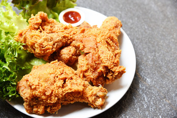 Fried chicken crispy on white plate with ketchup and salad lettuce vegetable on dark plate