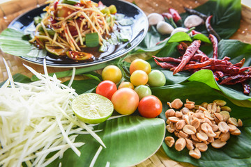 Papaya salad served on dining table - Green papaya salad spicy thai food on plate with herbs and spices ingredients with chilli tomato peanut garlic - Som tum Thai menu Asian food