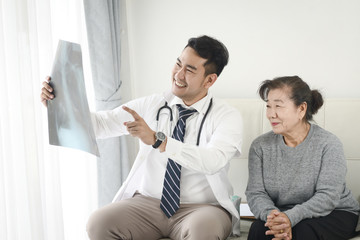 Doctor showing x-ray results to elderly woman
