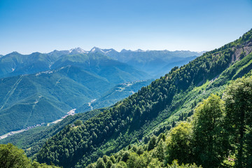 A panoramic view of the Valley with apartment buildings, surrounded by mountains with cable cars.