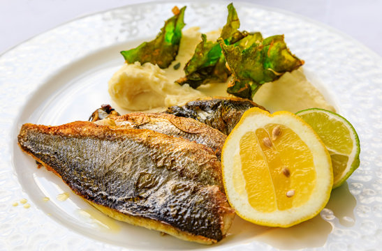 Pan seared branzino or sea bass with mashed potatoes and deep fried kale chips at an al fresco restaurant in Montenegro