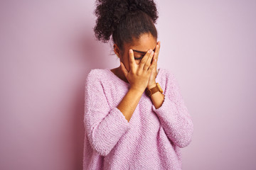 Young african american woman wearing winter sweater standing over isolated pink background with sad expression covering face with hands while crying. Depression concept.