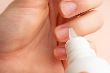 Nail care. Beautiful women hands making nails painted by pink delicate nail polish on a gentle background. Female hands near a set of professional manicure tools. Beauty care. Closeup manicure.