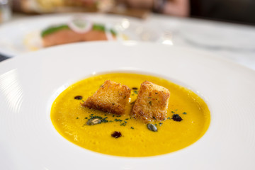 pumpkin soup on white plate in fine dinning restaurant