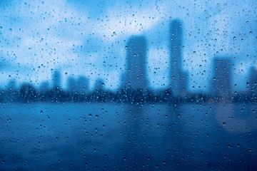 rain drops on glass over the river city