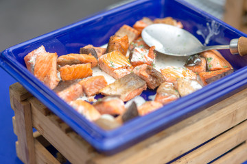 Grilled salmon cream sauce in blue tray on line catering buffet