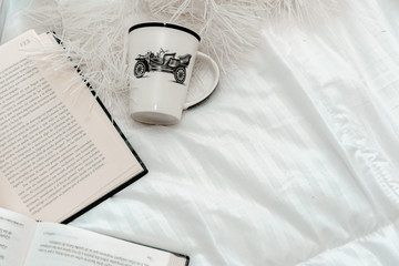 libros con un vaso en una cama elegante blanca 