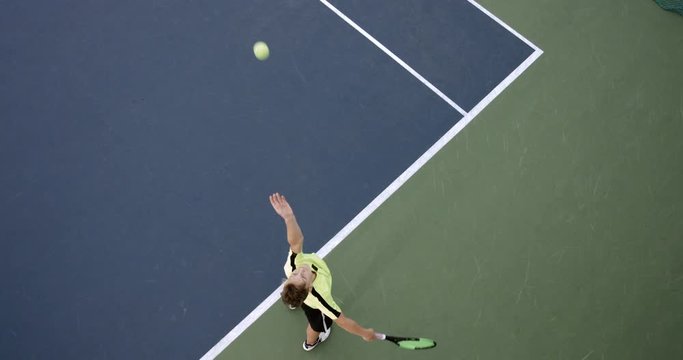 OVERHEAD CRANE Young Caucasian teenager male tennis player serving during a game or practice. Slow motion, 4K UHD RAW graded footage