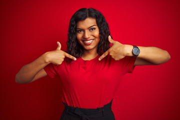 Beautiful transsexual transgender woman wearing t-shirt over isolated red background looking confident with smile on face, pointing oneself with fingers proud and happy.