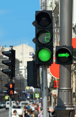 Images of green traffic lights and people..People are moving across the street and red traffic light.
