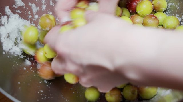 A Japanese female chef mixing salt with Japanese Ume (making UMEBOSHI) at home kitchen, Tokyo, Japan. May 2019. Camera fixed, Extreme close-up, high angle