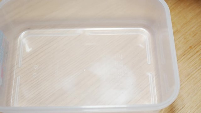 A Japanese female chef disinfecting a container to put Umeboshi (pickled Japanese Ume) at home kitchen, Tokyo, Japan. May 2019. Camera fixed, Extreme close-up, high angle