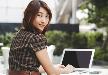 Beautiful business asian woman using a laptop computer on the table in outdoor cafe.