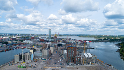 Fototapeta premium New modern buildings under construction in Helsinki. Sompasaari at summer day. Aerial view of beautiful bridge.