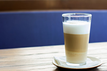 Latte glass on the table on the terrace of the summer cafe