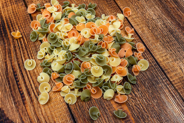 pasta colorata сolorful spaghetti, conchiglie, conchiglioni, macaroni on wooden background close up selective focus