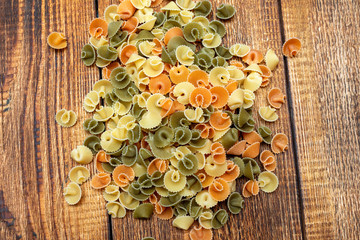 pasta colorata сolorful spaghetti, conchiglie, conchiglioni, macaroni on wooden background close up selective focus