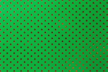 Dark green background from metal foil paper with a golden stars pattern.