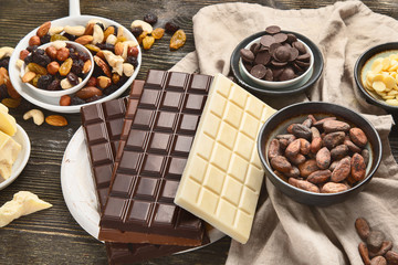 Dark bitter, milk and white chocolate,  cocoa butter, cacao powder and beans on wooden table.