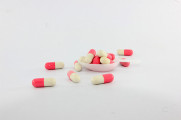 Obraz na płótnie Canvas Pink and white capsules on white background. Antimicrobial capsule pills, Pharmacy. 
