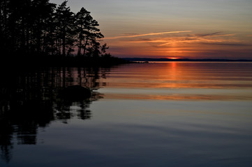 Fototapeta na wymiar orange sunset over a calm lake in Sweden