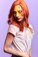 romantic beautiful girl with yellow eyelashes with bright red hair looking down. isolated blue background, studio shot