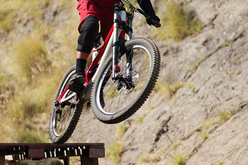 Naklejka premium Professional athlete high jumping downhill on the mountain bike cross-country