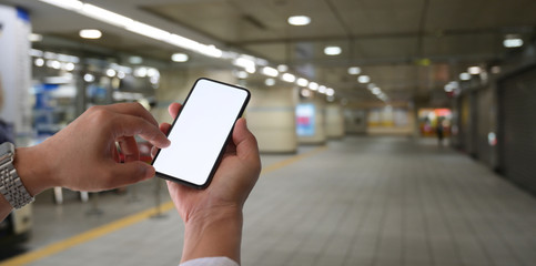 Man touching blank screen smartphone at railway station