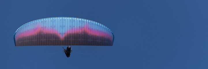 Paraglider tandem fly against the blue sky,tandem paragliding guided by a pilot