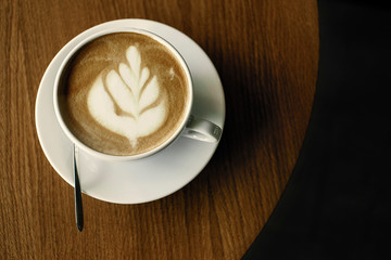Cup of hot cappucino on the wooden table. Early morning breakfast