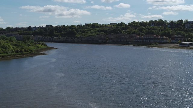 Aerial view over the River Medway, with a rising reveal of Rochester Castle, Cathedral & Town.