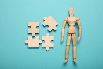 Wooden figure and puzzles, problem solving in business, new challenges. Innovation and teamwork.