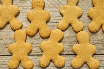 food background. Gingerbread cookies in shape of men on wooden table. Christmas sweets