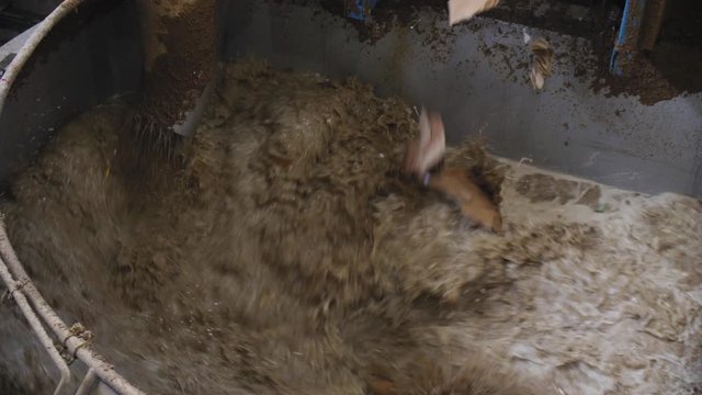 blocks of waste paper fall down into hot cellulose at plant