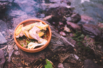 uncook chicken with thai herb in earth jar put on rock