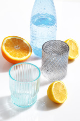 Composition of glassware and cut citrus fruits on a white background. The concept of making homemade lemonade.