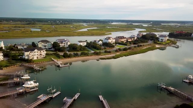 Early morning sunrise drone flyover to the left  over piers and houses at figure eight island inner harbor in Wilmington North Carolina