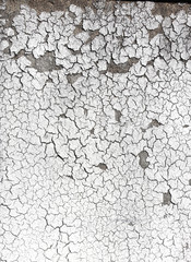 Texture of old wall with cracked stucco of white color