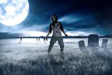 Scary zombies with blood and wound on his body walking around on the grass field